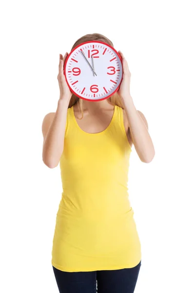 Casual caucasian woman holds clock on her face. — Stock Photo, Image