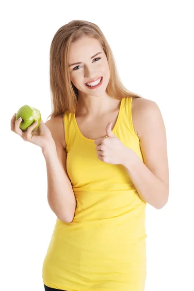 Mulher branca causal bonita segurando maçã verde fresca com mordida ausente . — Fotografia de Stock