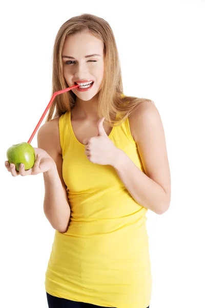 Mooie Kaukasische casual slanke vrouw sap drinken uit een appel met rietje. — Stockfoto