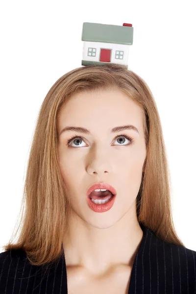 Beautiful caucasian business woman with house model on head. — Stock Photo, Image