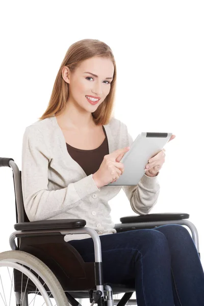 Tablet ile w tekerlekli sandalye üzerinde oturan güzel casual kadın. — Stok fotoğraf