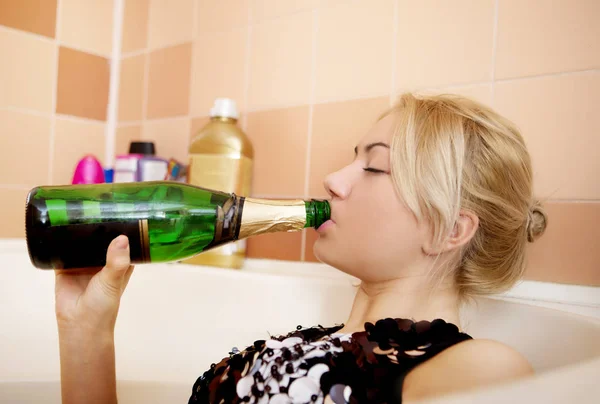 Teen kvinna dricker alkohol i bathtube. — Stockfoto