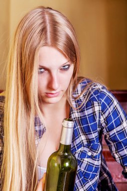 İçki şişesiyle sarhoş genç bir kadın.