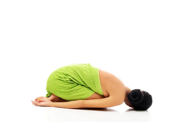 Woman curled up wrapped in towel — Stock Photo, Image