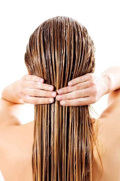 Donna che applica balsamo per capelli. Isolato su bianco. — Foto Stock