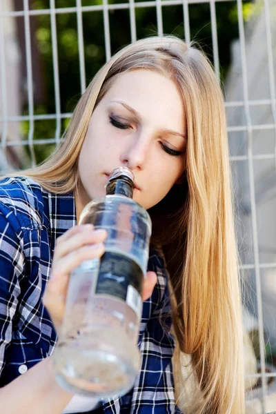 Mujer joven borracha con botella de alcohol —  Fotos de Stock