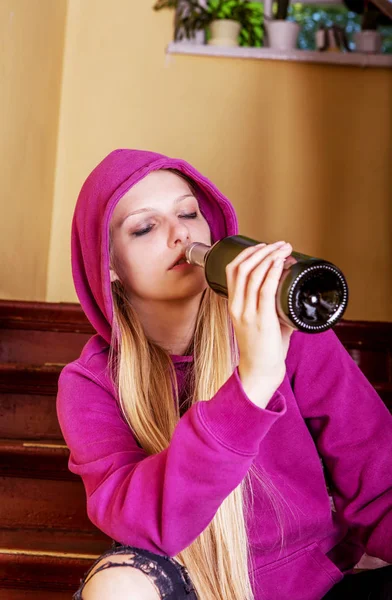 Fylld ung kvinna med flaska alkohol — Stockfoto