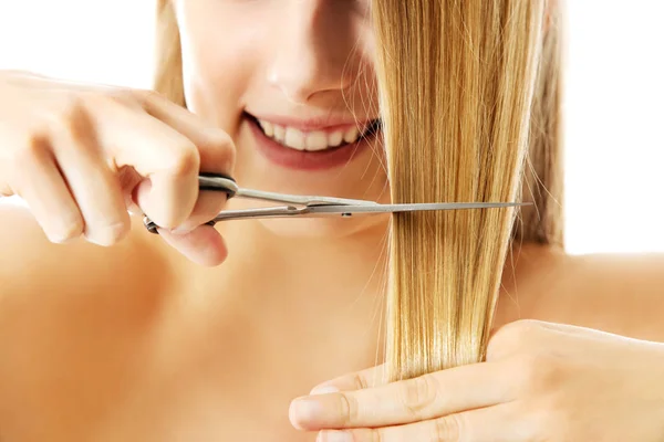 Jovem atraente está cortando seu longo cabelo natural — Fotografia de Stock