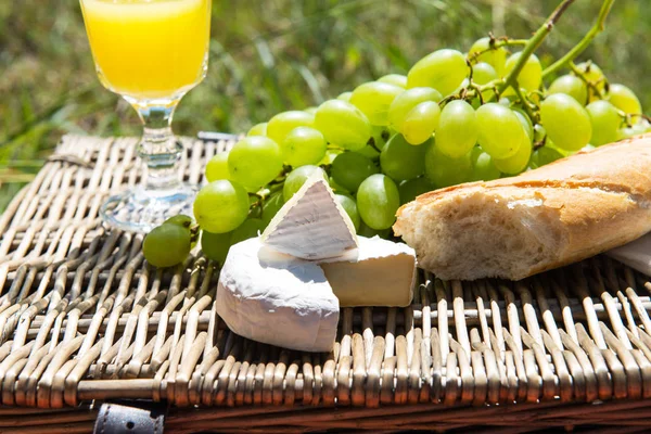 Picnic koncept - appelsinjuice, baguette, ost og druer - Stock-foto