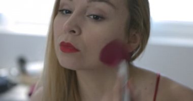 Kadın banyoda makyaj fırça kullanarak