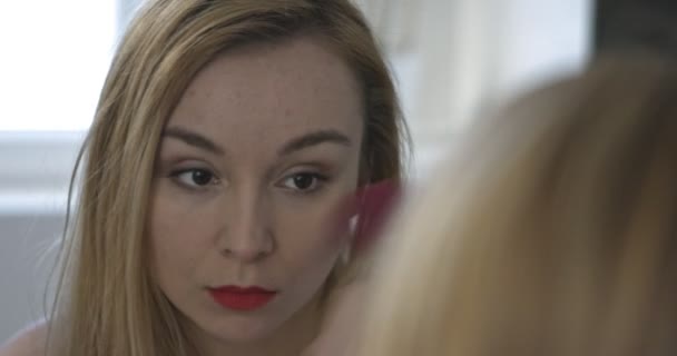 Kvinna i badrummet med hjälp av smink borste — Stockvideo