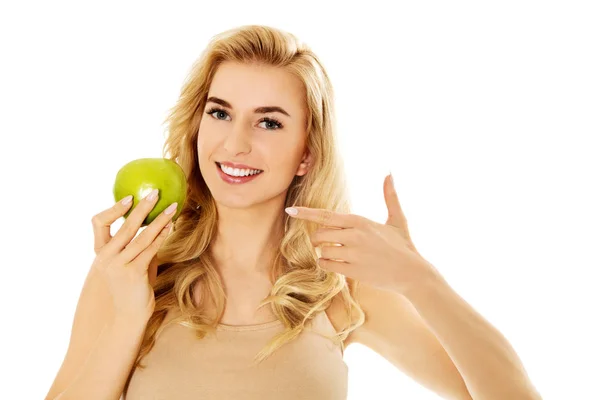 Молодая счастливая женщина ест свежее зеленое яблоко — стоковое фото
