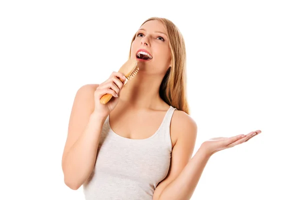 Chica joven cantando usando un cepillo como micrófono —  Fotos de Stock