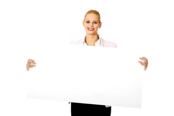 Sorrindo jovem empresária segurando banner em branco — Fotografia de Stock