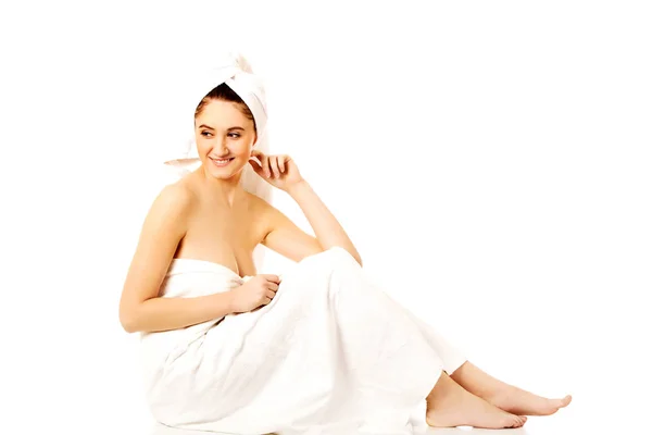 Joven sonrisa mujer envuelto toallas sentado —  Fotos de Stock