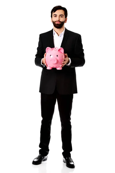 Empresário que detém um Piggy Bank. — Fotografia de Stock