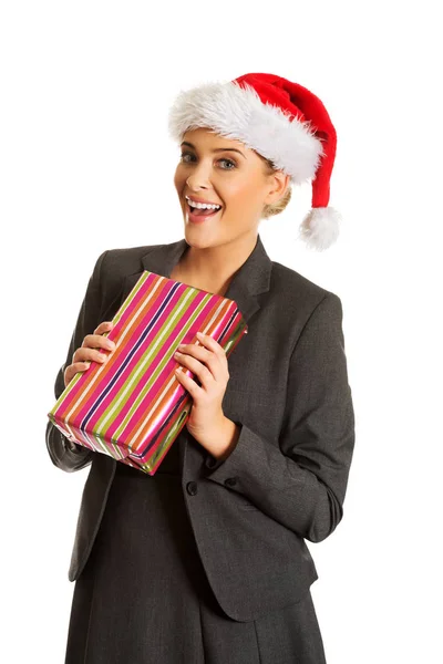 Woman weating Santa hat and holding a present — Stock Photo, Image