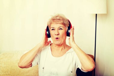 Kırmızı kulaklık takan mutlu son sınıf kadını. 