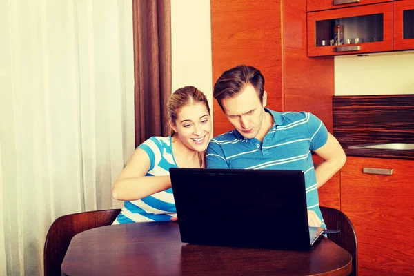 Casal jovem à procura de algo no laptop — Fotografia de Stock