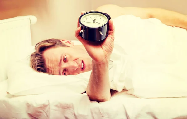 Muž se pokouší usnout, když zvoní budík — Stock fotografie
