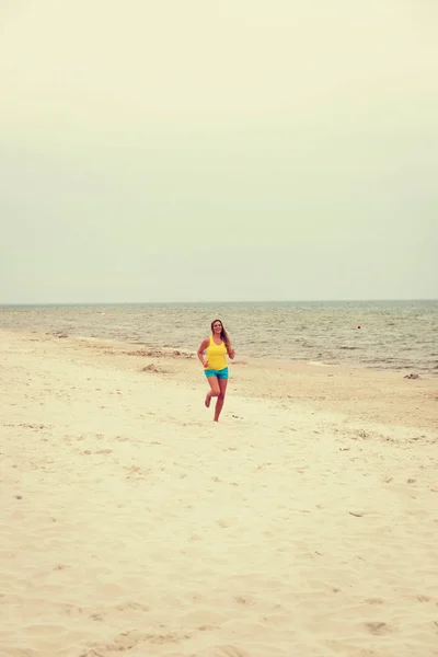 Jeune femme courant sur la plage — Photo