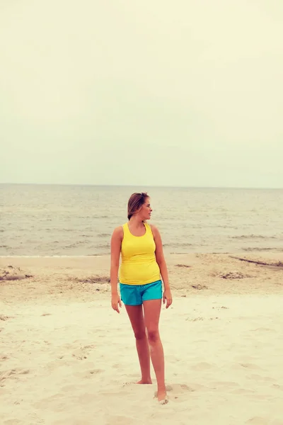 Уставшая женщина стоит на пляже — стоковое фото