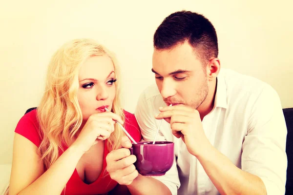 Cute couple drinking from one cup — Stock Photo, Image