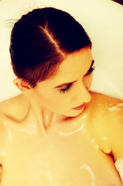 Kvinna avkopplande i badkar med bubbla — Stockfoto