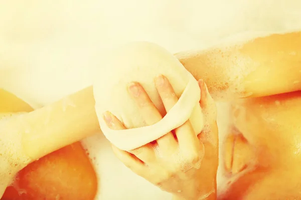 Vrouw wassen zichzelf door sponge — Stockfoto