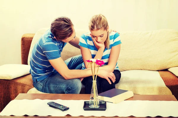 Man troostend zijn boos partner in woonkamer — Stockfoto