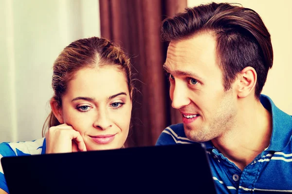 Pareja joven buscando algo en el ordenador portátil —  Fotos de Stock