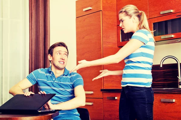 Man watching something on laptop, his wife is angry — Stock Photo, Image