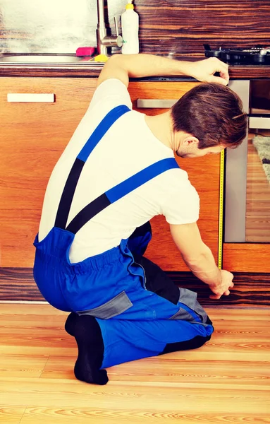 Joven hombre de reparación medición de gabinete de cocina — Foto de Stock