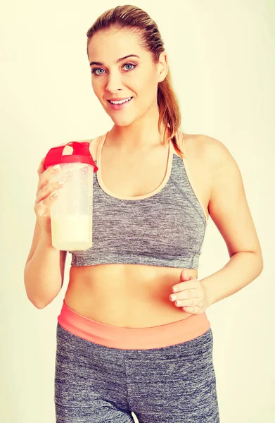 Mulher esportiva jovem com garrafa de batido de proteína — Fotografia de Stock
