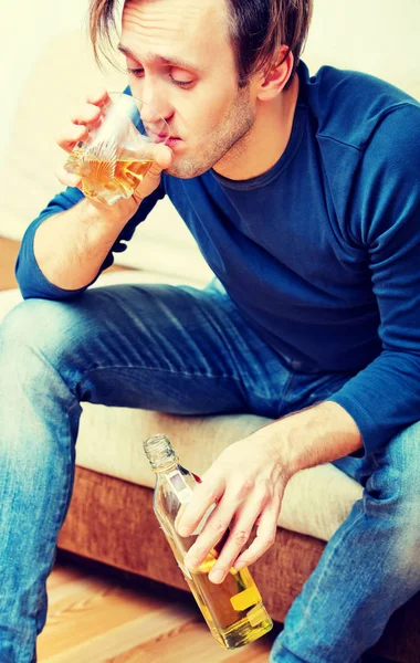 Betrunkener sitzt auf Couch und trinkt Whiskey — Stockfoto