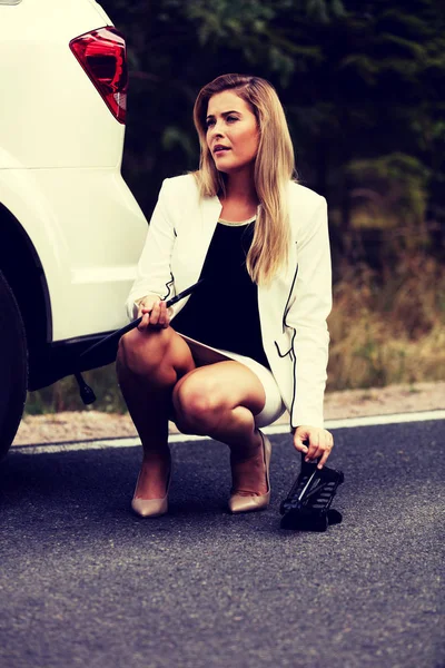 Jovem mulher segurando jacke e roda chave — Fotografia de Stock