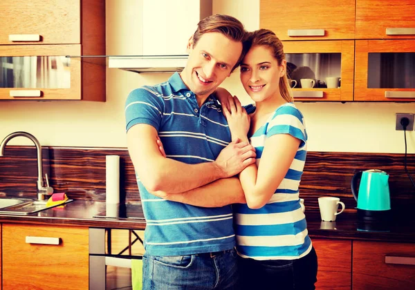 Krásný mladý pár stojící v kuchyni — Stock fotografie