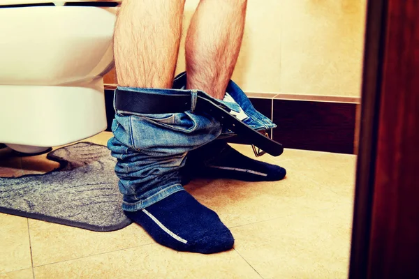 Mannen som sitter på en toalettsits — Stockfoto