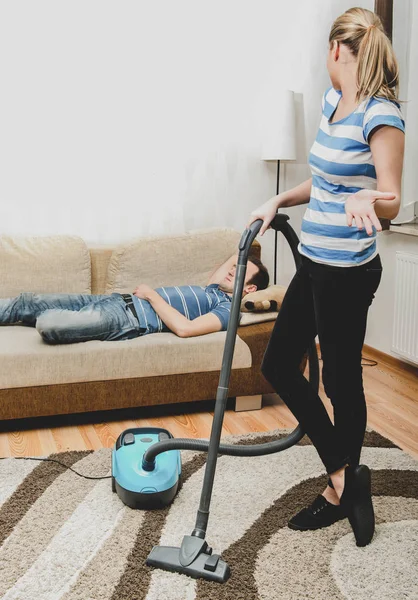 Frau, die zu Hause Hausarbeiten erledigt. Den Teppich aussaugen — Stockfoto