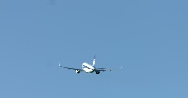 Flugzeug fliegt unter strahlend blauem Himmel — Stockvideo