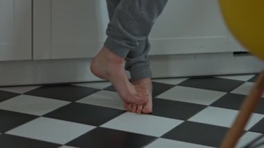 Mutfakta yerde üzerinde çıplak ayak. Ev iç. Başlangıç günü.