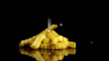 Kızarmış patates tuz ekleyerek ağır çekim görüntüleri.