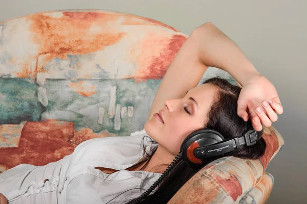 Leżąca kobieta ze słuchawkami — Zdjęcie stockowe