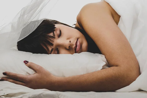 Brünette schlafen im bett — Stockfoto