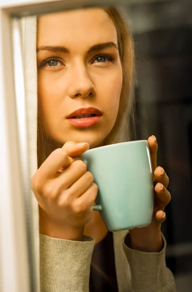 Mulher com xícara de café na janela — Fotografia de Stock