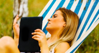 Bir hamakta tablet kullanan kadın.