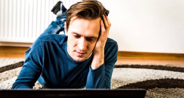 Dizüstü bilgisayarda çalışan bitkin adam