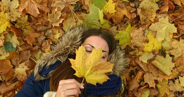 Junge Frau im Herbstpark mit Blättern — Stockfoto