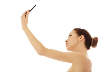 Genç çıplak kadın selfie çekiyor.