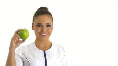 Hemşire ya da genç doktor gülümseyen bir elma tutuyor..
